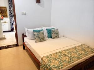 米瑞莎Asanka Beach Stay的一间卧室配有带枕头的床
