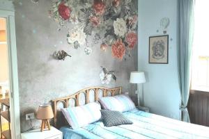 维杰瓦诺Interno 15 Diario di viaggio的卧室配有一张墙上鲜花的床