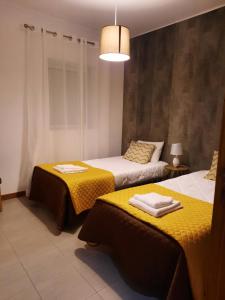 Vila NovaVila Nova House的一间卧室配有两张带毛巾的床