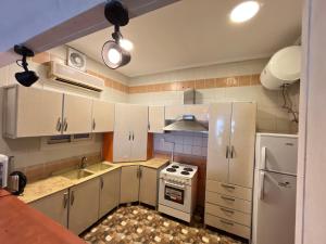 杜拉特阿拉尔شالهيات درة العروس的厨房配有白色橱柜、炉灶和冰箱。