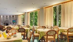 约阿尼纳迪奥尼酒店的用餐室设有桌椅和窗户。