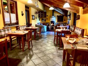 瓦尔佩利内丽维阿穆尔酒店的餐厅设有木桌、椅子和壁炉