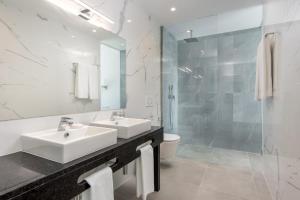 拉戈斯Vila Luna B&B的白色的浴室设有2个盥洗盆和淋浴。