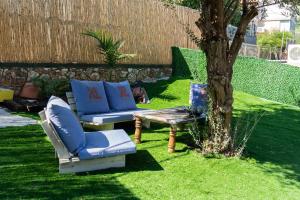 提比里亚ספא מור Spa Mor的花园配有沙发、桌子和树