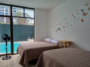 危地马拉Central Hostel的墙上有蝴蝶的房间的两张床