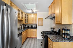 圣布鲁诺Cozy 2 Bedroom Home Near SFO with Private Parking的厨房配有木制橱柜和不锈钢冰箱。