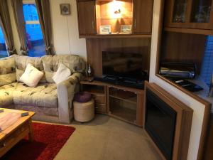 桑当First Steps Caravan Rentals的带沙发和平面电视的客厅
