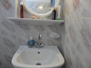 佩里沃罗Nikolas Villas的浴室水槽和墙上的镜子