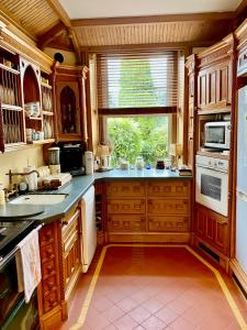 新罗斯Victorian Villa的一个带木制橱柜和窗户的大厨房