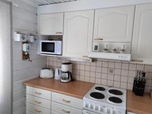 罗瓦涅米Villa Bear's的厨房配有白色橱柜、炉灶和微波炉。