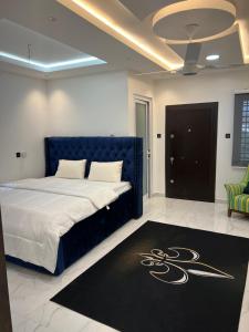 阿克拉HMS SEA VIEW VILLA的一间卧室配有一张蓝色的床和黑色地毯