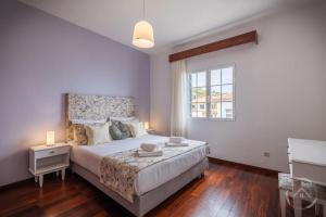 丰沙尔Garden House的一间卧室设有一张大床和一个窗户。