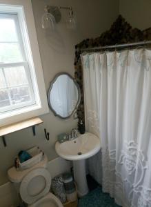 巴拿马城海滩Hidden Gem Guest House的一间带水槽、卫生间和镜子的浴室