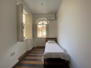萨尔瓦多Sunflower Hostel的一个小房间,在带窗户的房间里设有一张床