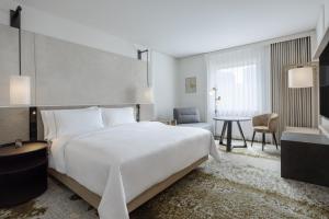 美因河畔法兰克福法兰克福威斯汀大酒店的卧室配有一张白色的大床和一张桌子