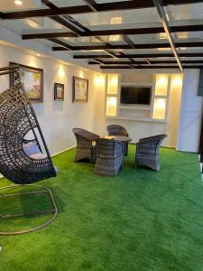 塔伊夫فندق الورد الذهبي的配有椅子和桌子以及平面电视的房间