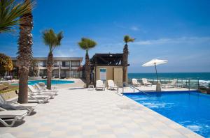 阿里卡阿里卡泛美酒店的一个带游泳池和椅子的度假胜地和大海