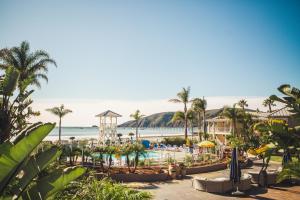 阿维拉海滩阿维拉灯塔套房酒店的一个带游泳池和棕榈树海滩的度假胜地