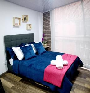 波哥大Nuevo Loft completo 34 Corferias Movistar Arena Campin HOST-MI的一间卧室配有一张蓝色的床和红色毯子