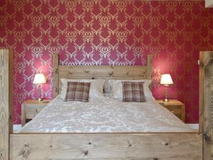 戈尔斯皮Drummuie House的一间卧室配有一张带红色壁纸的大床