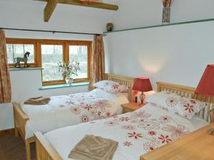 博德明斯戴普斯乡村别墅的一间卧室设有两张床和窗户。