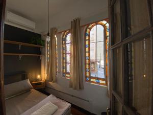 蒙得维的亚Youki Haus Hostel的一间卧室设有床铺和彩色玻璃窗