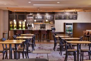 奥卡拉欧卡拉万怡酒店的一间带木桌椅的餐厅和一间酒吧