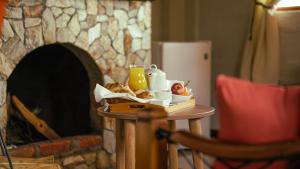 万卡约Tuki Llajta - Pueblo bonito Lodge的壁炉旁带食物托盘的桌子