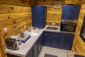 阿哈达أكواخ غيم ومطر的厨房配有蓝色橱柜和水槽
