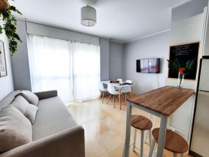 塞维利亚Triana Suite Torre Sevilla, parking free gratis!的客厅配有沙发和桌子