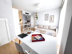 塞维利亚Triana Suite Torre Sevilla, parking free gratis!的客厅配有白色的桌子和椅子