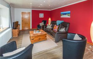 AchtrupAm Moor的客厅设有红色的墙壁、沙发和椅子