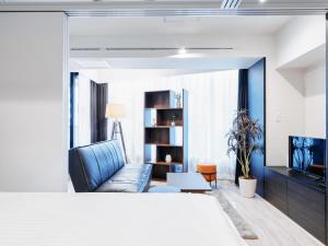 东京Sukumo -蒅-的客厅配有蓝色的沙发和电视