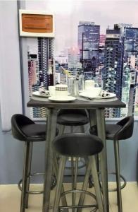 马尼拉Chic 2BR Condo Unit at South Residences的一张桌子和四把椅子,享有城市美景