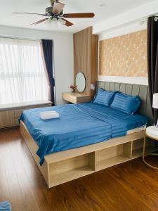 下龙湾Three-bedroom house with sea view的一间卧室配有一张带蓝色床单的床和风扇