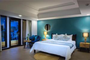 暹粒Sokchea Angkor Hotel的一间卧室设有一张蓝色墙壁的大床