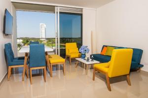 蒙特里亚Apartamento acogedor的用餐室配有黄色和蓝色的椅子和桌子