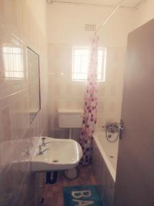卢萨卡Salama House的浴室配有盥洗盆、卫生间和浴缸。