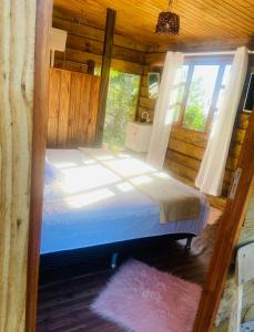 塞尔苏拉穆斯州长镇Recanto da Vila - Suíte 01的小木屋内一间卧室,配有一张床