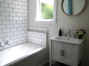 格雷敦Country Bliss Cottage的白色的浴室设有浴缸和水槽。
