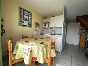 埃尔德旺Appartement Erdeven, 3 pièces, 4 personnes - FR-1-397-68的一间带桌子的厨房和一间带冰箱的厨房