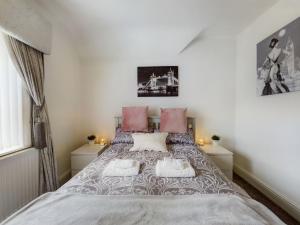 切斯特Zoo Cottage的卧室配有一张带粉红色枕头的大床