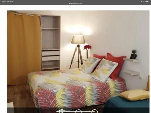 比兹米内瓦La Villa du Menhir Gîte的一间卧室配有带色彩缤纷枕头的床