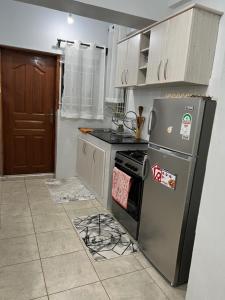 KerichoComfortplace 2 bedroom的厨房配有冰箱和炉灶。 顶部烤箱