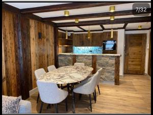 谷雪维尔Luxury suite 70m2 balcon courchevel1850 parking的一间带桌子和白色椅子的用餐室