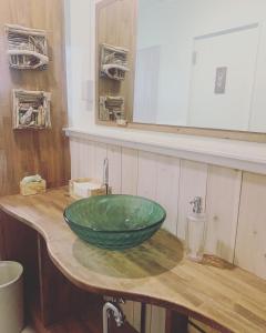 Kanzaki Beach House的浴室水槽和木台上的绿色碗