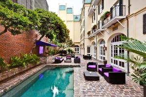 新奥尔良勒马拉斯酒店的一个带游泳池和椅子的庭院和一座建筑