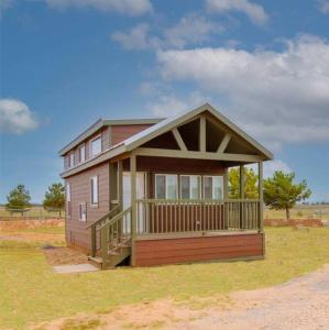 瓦莱037 Tiny Home nr Grand Canyon South Rim Sleeps 8的田野上带门廊的小房子