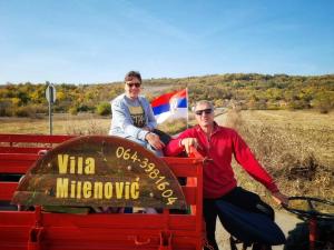 RajacVila Milenovic Rajacke Pivnice的坐在一辆红色卡车后面的两个人