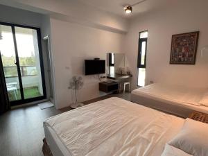 马公鸟窝民宿的一间卧室设有两张床、一台电视和一扇窗户。